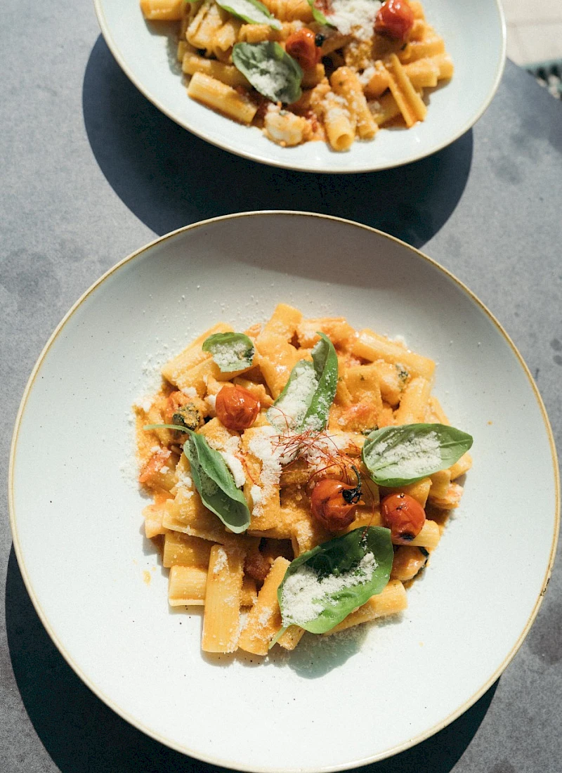 Pasta dish with fresh basil, tomatoes and Parmesan cheese.