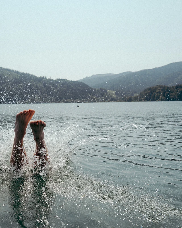 Diving into Lake Schliersee with mountains in the background